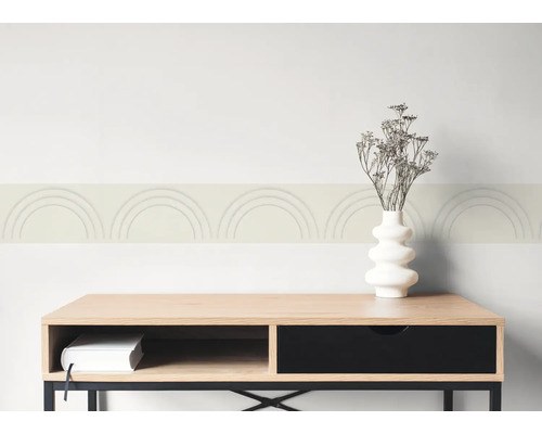 Tapetenbordüre mit Bogenmuster an einer Wand über einem Sideboard aus Holz mit Vase und getrockneten Blumen.