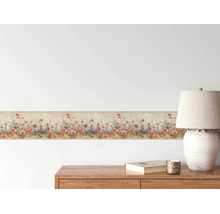 Tapetenborte mit Mohnblumenmuster an einer Wand über einer Holzkommode mit Tischlampe in einem hellen Raum.