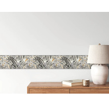 Helle und organisierte Raumszene mit einer Tapetenbordüre im Palmenblatt-Design an der Wand über einem Sideboard aus Holz mit einer Tischleuchte.