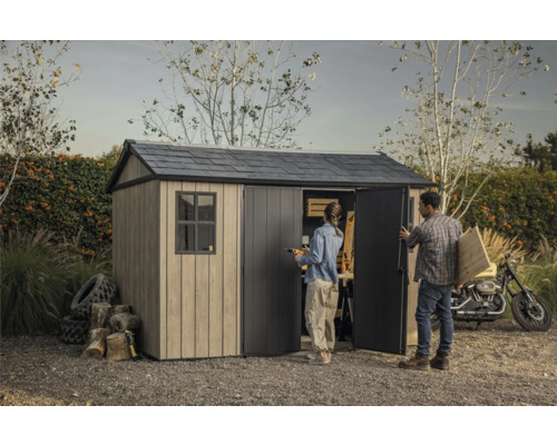 Gartenszene mit Gerätehaus, Personen, Motorrad, Holz und Werkzeugen.