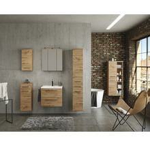 Badezimmermöbel-Set in Eichenoptik vor einer Betonwand, mit Waschtischunterschrank, Spiegelschrank und Hängeschränken im Industriedesign.