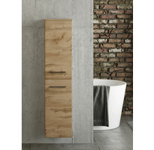 Badezimmer-Hochschrank in Eichenoptik mit schwarzen Griffen an einer Betonwand. Im Hintergrund eine Ziegelwand und eine freistehende Badewanne.