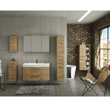 Modernes Badezimmer im Industrial-Stil mit Badmöbelset in Eichenoptik, Waschbeckenunterschrank, Spiegelschrank und Hochschränken vor Betonwand.