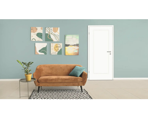 Wohnzimmer mit Sofa, Zimmerpflanze, Teppich und Kunst an der Wand