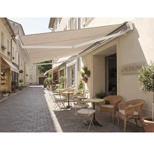 Außenbereich eines Cafés mit Markise und Sitzgelegenheiten auf einer gepflasterten Straße