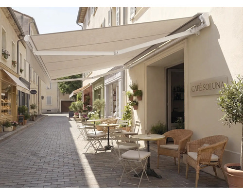 Außenbereich eines Cafés mit Markise und Sitzgelegenheiten auf einer gepflasterten Straße