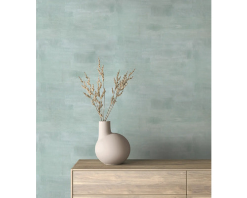 Wohnraum mit beiger Vase und Trockenblumen auf Holzkommode vor Wand