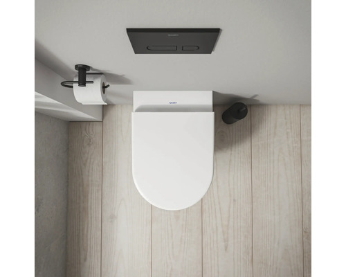 Aufnahme von oben einer Toilette mit Toilettenpapierhalter und Spülkasten