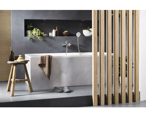 Badezimmer mit Badewanne, Armatur, Deko und Holzabtrennung für eine moderne Atmosphäre