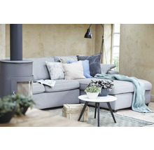 Wohnzimmer mit grauem Sofa, Kaminofen, Beistelltisch und dekorativen Elementen für eine gemütliche Atmosphäre