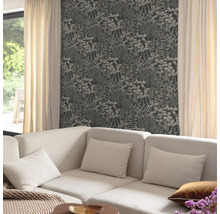 Wohnzimmer mit floral gemusterter Tapete und einem Sofa