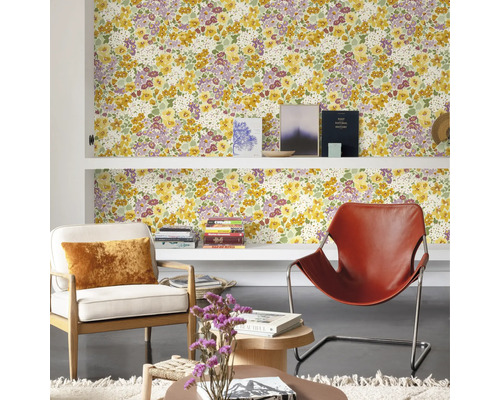 Wohnzimmer mit floraler Tapete, Regalen und Sesseln