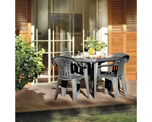 Gartenszene mit rundem Tisch und vier Stühlen auf einer Holzterrasse