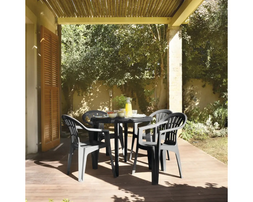 Gartenszene mit einem schwarzen Gartentisch und vier passenden Gartenstühlen auf einer Terrasse