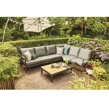 Gartenszene mit grauer Loungegarnitur, Couchtisch, Sonnenschirm und Lichterkette