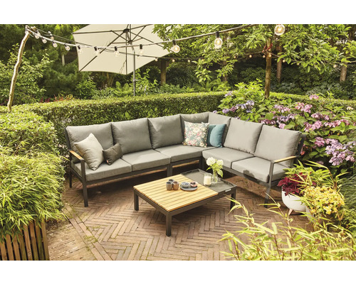 Gartenszene mit grauer Loungegarnitur, Couchtisch, Sonnenschirm und Lichterkette