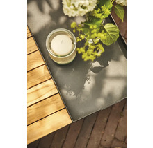 Dekorationstablett mit Kerze und Blumen auf einem Gartentisch