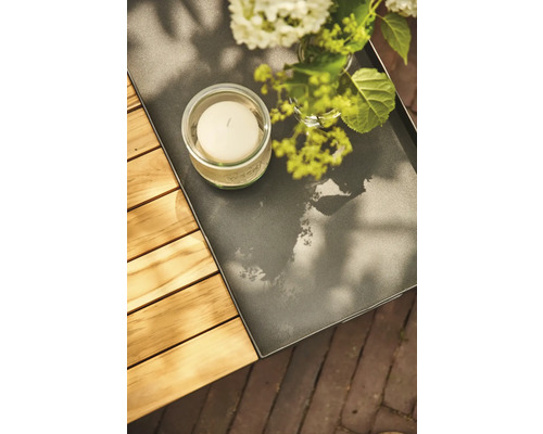 Dekorationstablett mit Kerze und Blumen auf einem Gartentisch