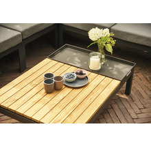 Gartentisch mit Holzplatte, Getränken, Kerze und Blumen auf einer Terrasse