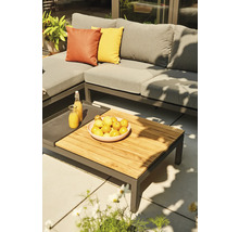 Gartenszene mit grauer Loungegarnitur, Holztisch, Obstschale und Getränken