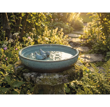 Vogeltränke mit Vogelfigur und Spatz im Garten