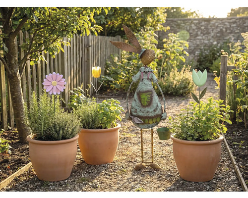 Gartenszene mit bepflanzten Terrakottatöpfen, Blumensteckern und einer Gartendekoration in Hasenform