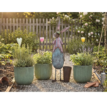 Gartenszene mit bepflanzten Töpfen, Metallhase und Dekorationen auf einem Kiesweg