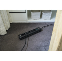 Mehrfachsteckdose mit sechs Steckplätzen und Schalter auf einem Teppich