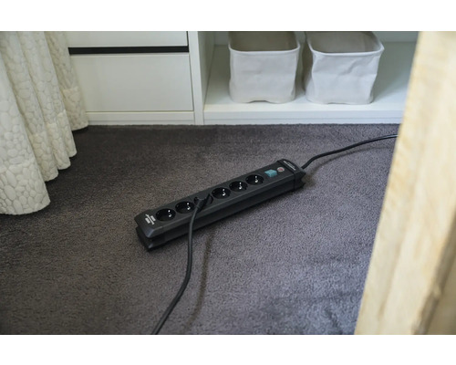 Mehrfachsteckdose mit sechs Steckplätzen und Schalter auf einem Teppich