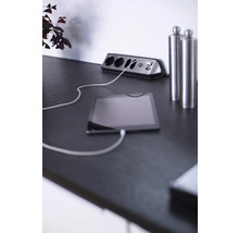 Steckdosenleiste mit USB-Anschlüssen und angeschlossenem Tablet auf einem Tisch