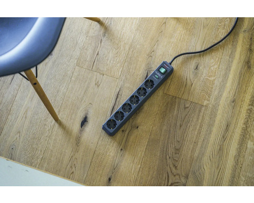 Steckdosenleiste mit sechs Steckdosen auf Holzboden