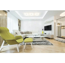 Helles modernes Wohnzimmer mit weißem Ecksofa, limettenfarbenem Sessel mit Hocker, grauem Teppich, Couchtisch und hellem Holzfußboden.