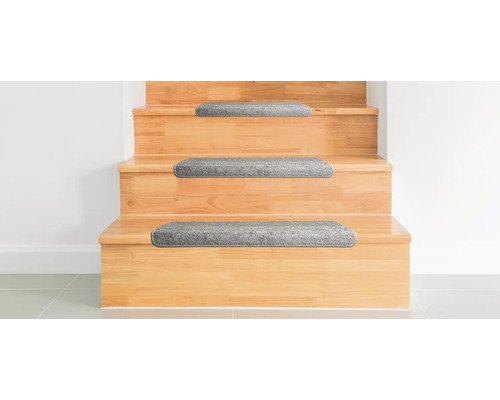 Holztreppe mit grauen Stufenmatten.