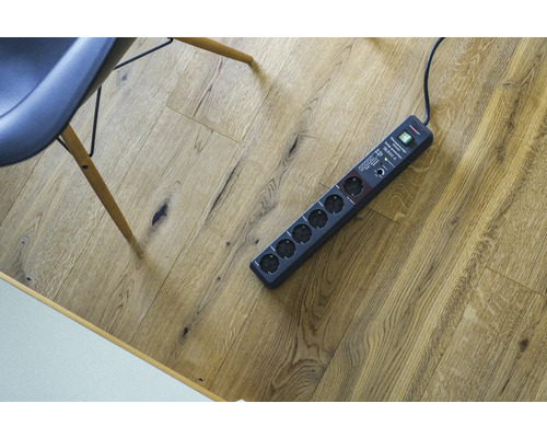 Steckdosenleiste mit sechs Steckplätzen auf Holzboden