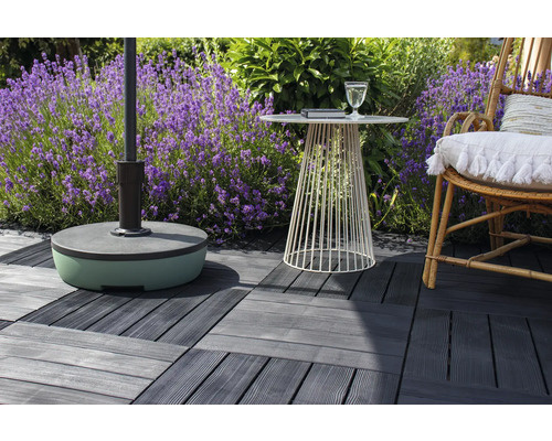 Terrassenszene mit Sonnenschirmständer, kleinem Tisch, Stuhl und Terrassenfliesen