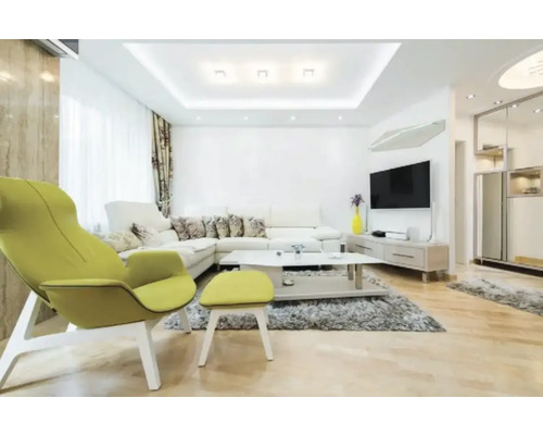 Helles modernes Wohnzimmer mit weißem Ecksofa, limettenfarbenem Sessel mit Hocker, grauem Teppich, Couchtisch und hellem Holzfußboden.