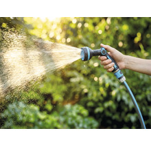 Hand hält Gartenschlauch mit Sprühkopf