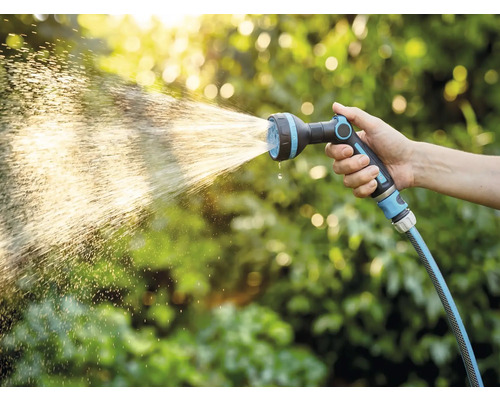 Hand hält Gartenschlauch mit Sprühkopf