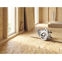 Rohbau eines Zimmers mit OSB-Platten, Kreissäge, Fenstern und Messwerkzeug