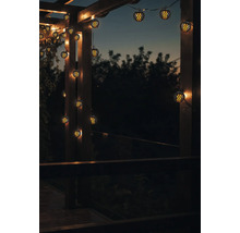 Dekorative Lichterkette mit kugelförmigen Lampen an einer Holzpergola