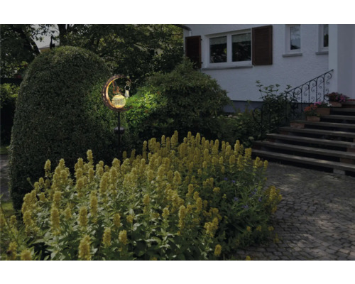 Leuchtender Mond mit Fee als Gartendekoration im Außenbereich.