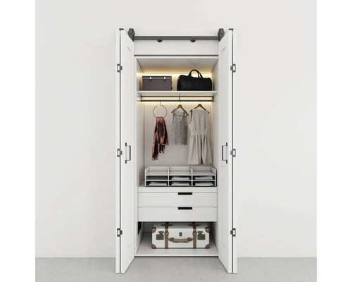 Offener weißer Kleiderschrank mit Kleidung und Aufbewahrungsboxen