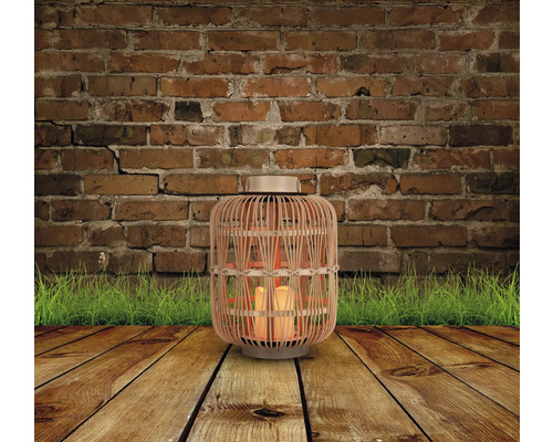 Dekorative Laterne aus Bambus mit Kerzen auf Holzboden vor Backsteinmauer