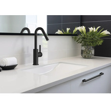 Waschbecken mit schwarzer Armatur, Handtuch und Blumenvase im Badezimmer