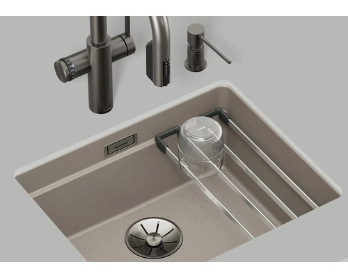 Spüle mit Wasserhahn, Spülmittelspender und Abtropfgestell im Spülbecken