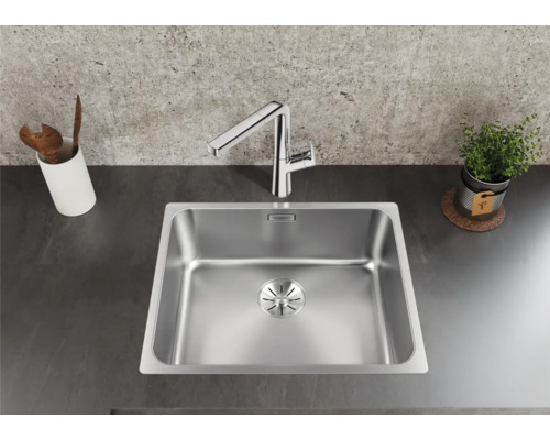 Spüle aus Edelstahl mit Armatur auf einer Küchentheke.