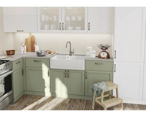 Küchenszene mit Spüle, Armatur, Küchenwaage und Küchenutensilien vor Unterschränken in Landhausoptik