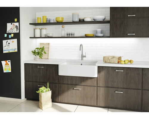 Küchenspüle mit Armatur, Unterschränken, Arbeitsplatte, Regalen und Dekoration