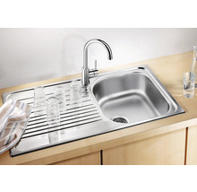 Edelstahlspüle mit Abtropffläche und Wasserhahn, darauf Gläser zum Trocknen