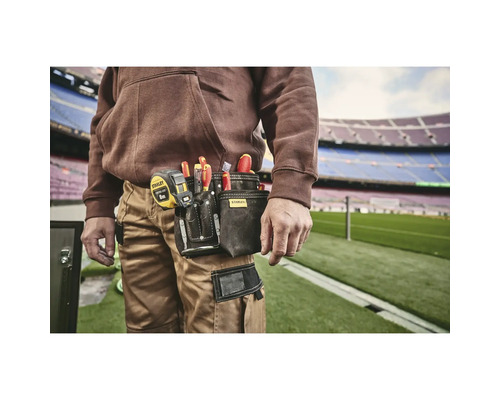 Handwerker mit Werkzeugtasche am Gürtel, gefüllt mit Schraubendrehern und einem Maßband von Stanley
